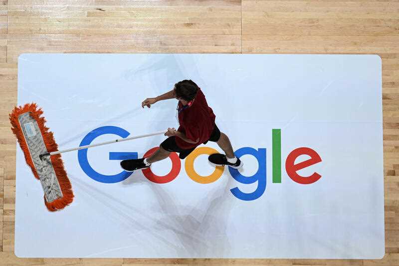A member of staff cleans an advert for Google during the 2022 FIBA Women's Basketball World Cup Quarter Final match between USA and Serbia at Qudos Bank Arena in Sydney, Thursday, September 29, 2022