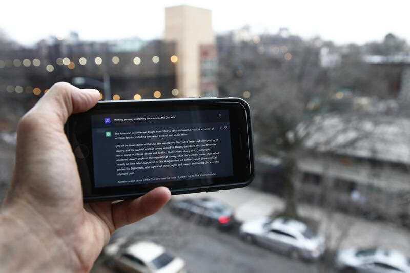 A ChatGPT prompt is shown on a handheld device