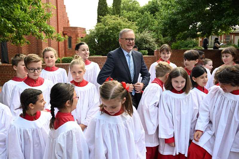 Prime Minister Anthony Albanese poses with the children’s choir after a Parliamentary church service to mark the opening of the parliamentary year in Canberra, Monday, February 6, 2023