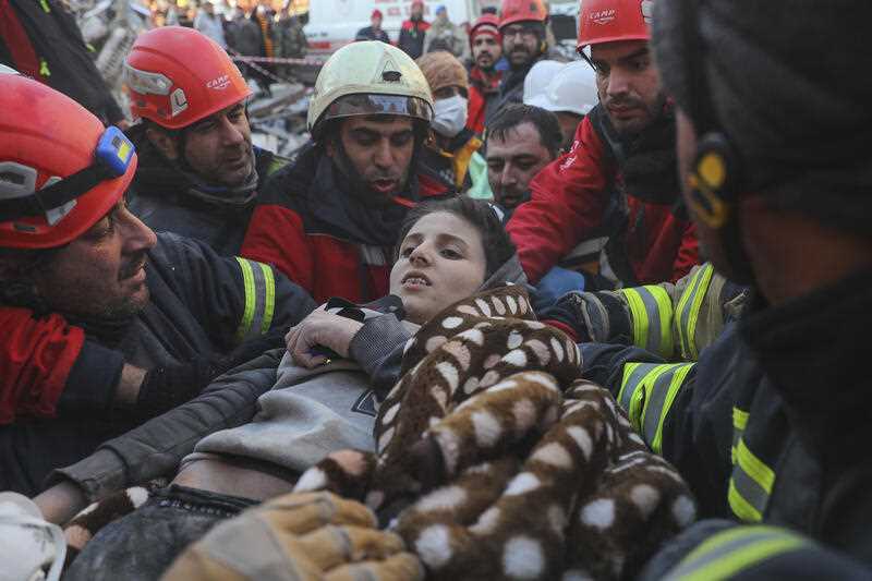 Rescuers carry Muhammed Alkanaas, 12, to an ambulance after they pulled him out five days after the Monday earthquake in Antakya, southern Turkey, late Saturday, Feb. 11, 2023