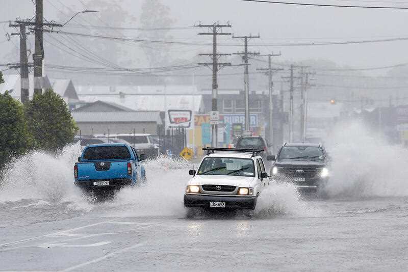 Cars move through flooded roads in the northern New Zealand city of Whangarei as Tropical Cyclone Gabrielle hits the Northland, Sunday, Feb. 12, 2023