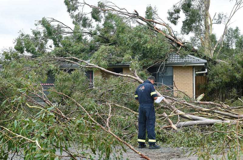 a house is surveyed for damage after strong winds, heavy rain and a hail storm