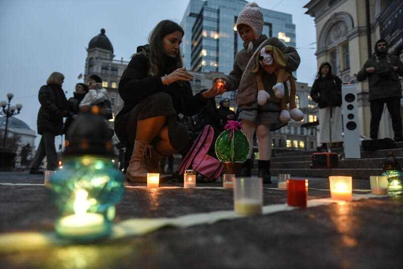 A woman and a girl light candles and arrange them to form the word 'Children' as they attend a commemorative rally to mark the first anniversary of the bombing of the Mariupol Drama Theatre, in front of the National Opera of Ukraine in Kyiv (Kiev), Ukraine, 16 March 2023