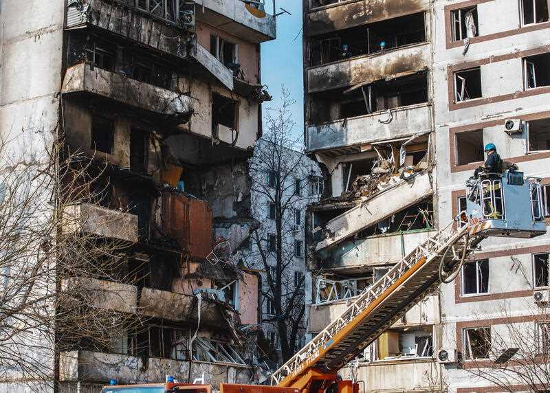 Rescuers work at a residential building after it was hit in a missile strike in Zaporizhzhia, Ukraine, 22 March 2023