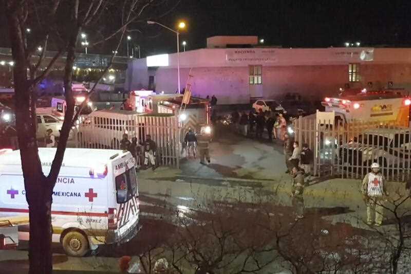ambulances and rescue teams staffers outside an immigration center in Ciudad Juarez, Mexico, Tuesday, March 28, 2023, where at least three dozen migrants have died in a fire