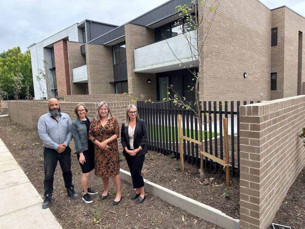 a man and 3 women standing outside new public housing development in Dickson ACT