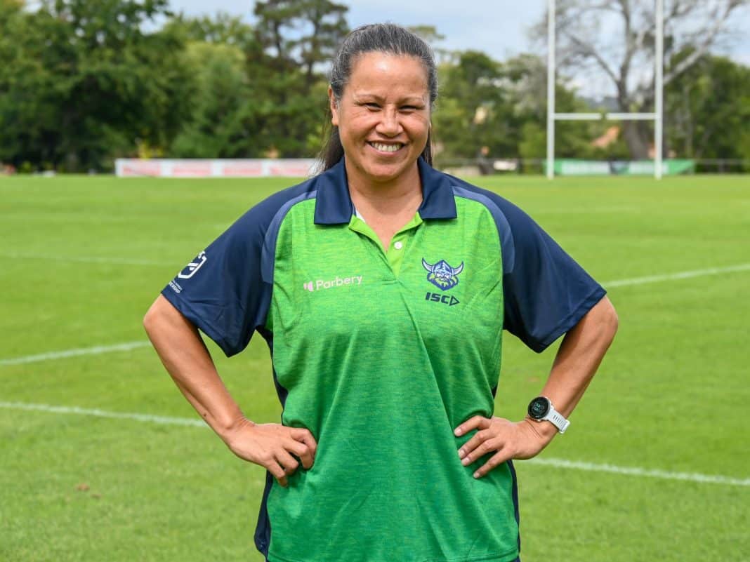 Canberra Raiders Women’s Wellbeing and Education Manager Lisa Fiaola in Raiders club shirt standing on rugby league playing field