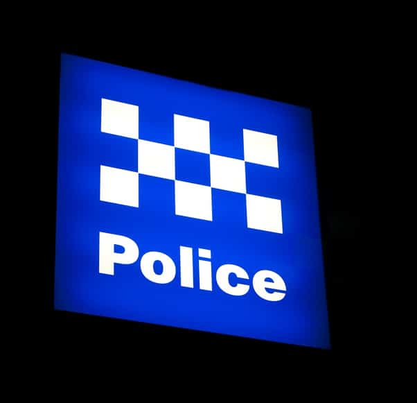 An Australian Police sign lit at night.