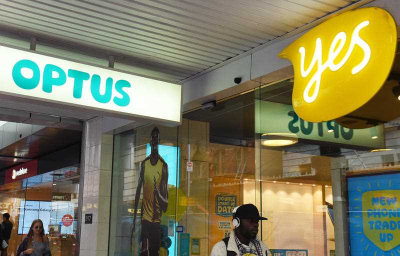 A man walks past an Optus store in Sydney