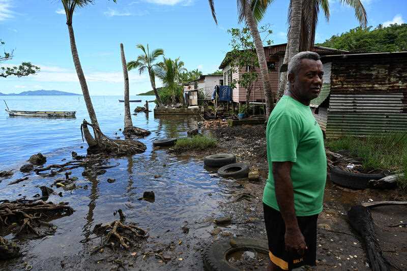 Local villager Tuiverata with houses affected by rising sea levels during the Fijian election campaign in the village of Veivatuloa, 35kms west of Suva, Fiji, Tuesday, December 13, 2022