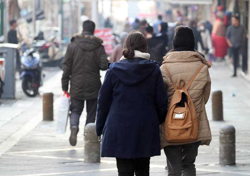Iranian women some without Hijab (head scarf) walk in a street in Tehran, Iran