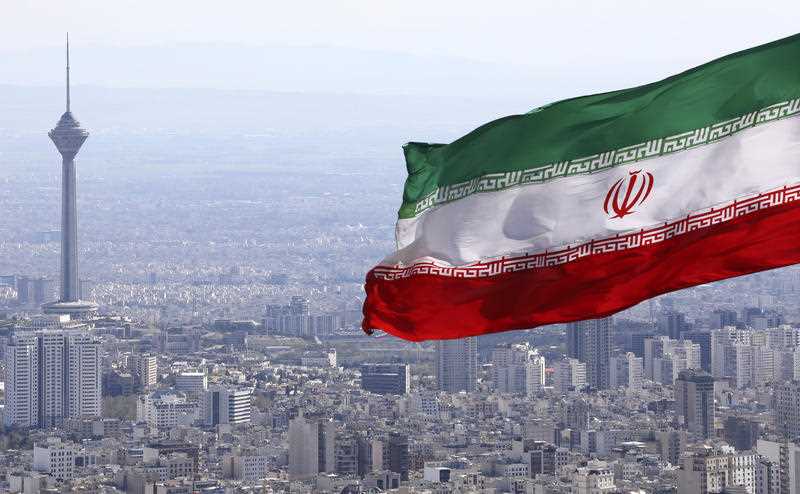 Iran's national flag waves as Milad telecommunications tower and buildings are seen in Tehran