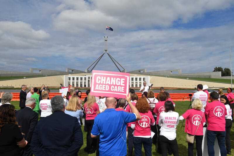 Aged care workers are seen protesting outside Parliament House in Canberra, Wednesday, March 30, 2022