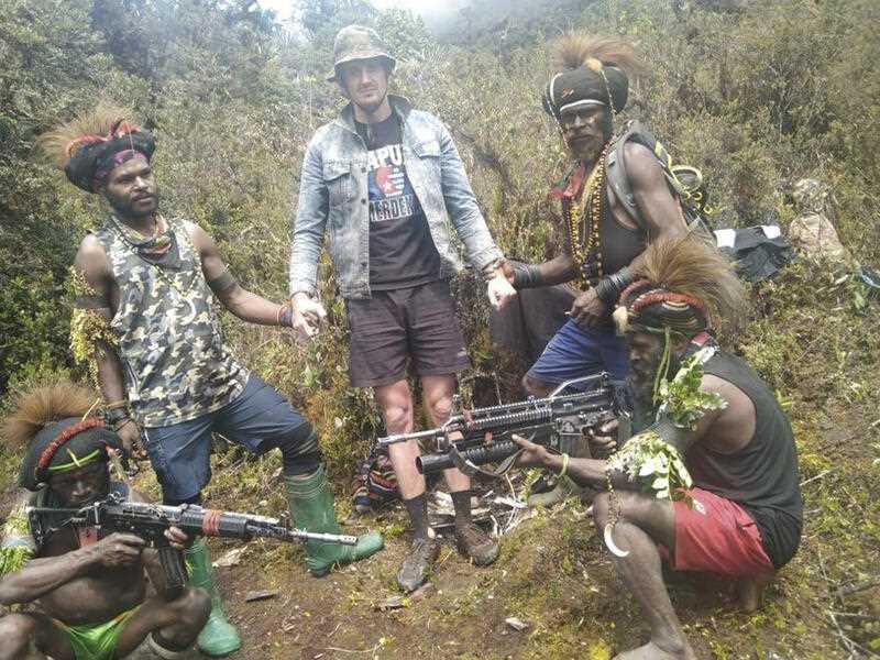 Papuan separatist rebels pose for a photo with a man they said is New Zealander pilot Phillip Mark Mehrtens who they took hostage last week, at an undisclosed location in Papua province, Indonesia