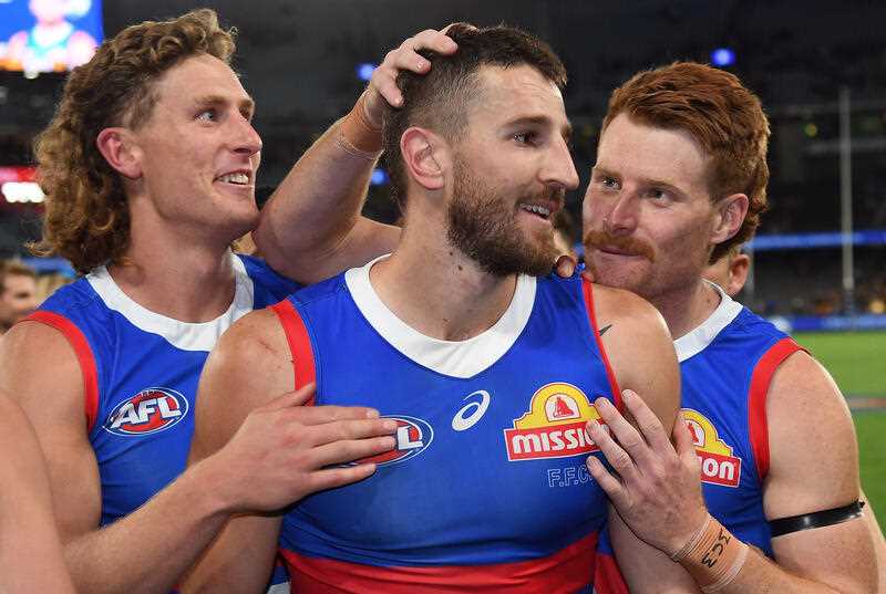 2 Western Bulldogs players are seen congratulating captain Marcus Bontempelli after a win