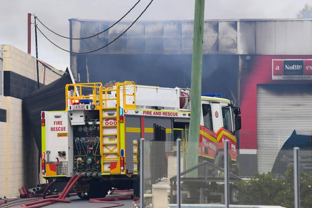 Firefighter critical as crews contain factory blaze south of Brisbane