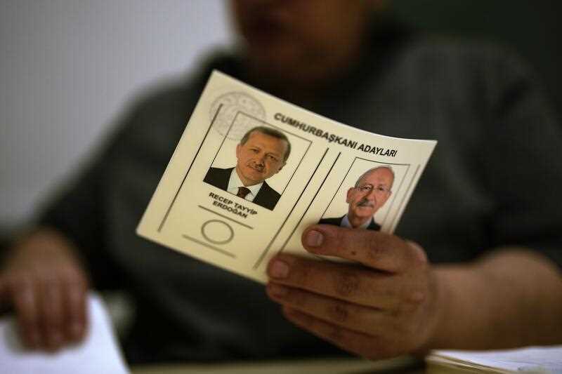 An election representative holds a ballot with presidential candidates at a polling station in Istanbul, Turkey, Sunday, May 28, 2023