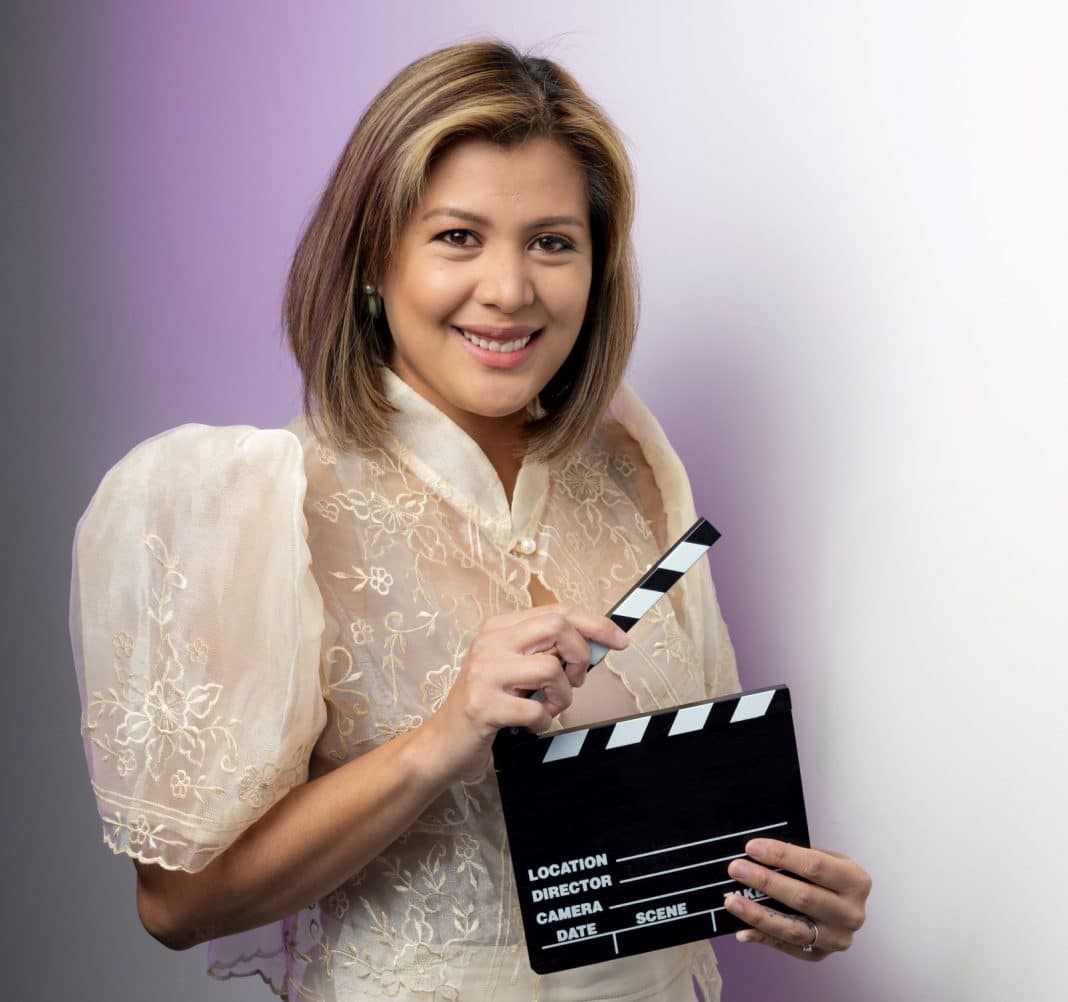 beautiful Filipina actress Rich Asuncion holding a clap-board