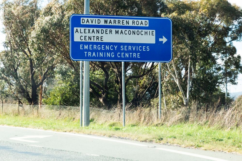 blue road sign pointing to Canberra prison, the Alexander Maconochie Centre