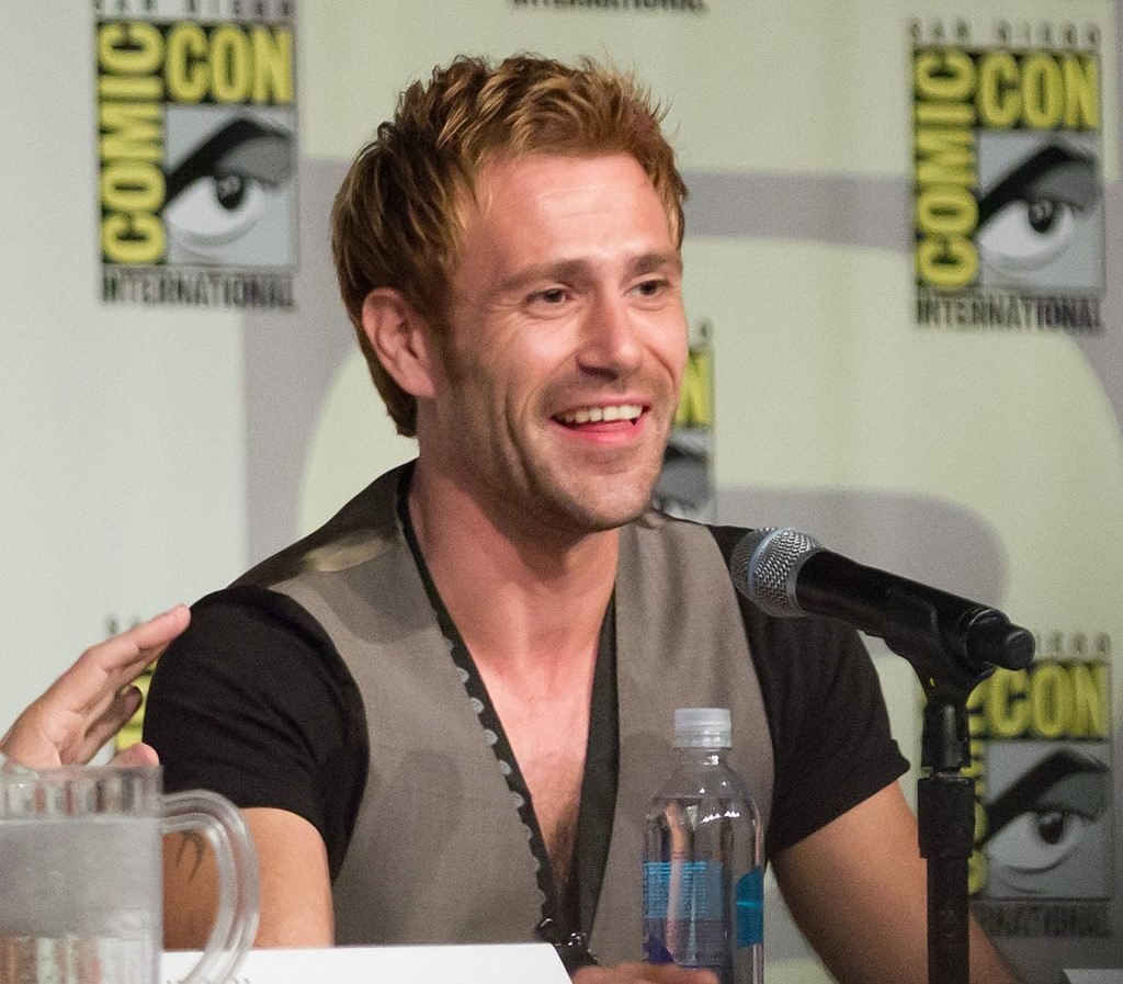 handsome smiling Welsh actor Matt Ryan speaking at a Comic-Con event