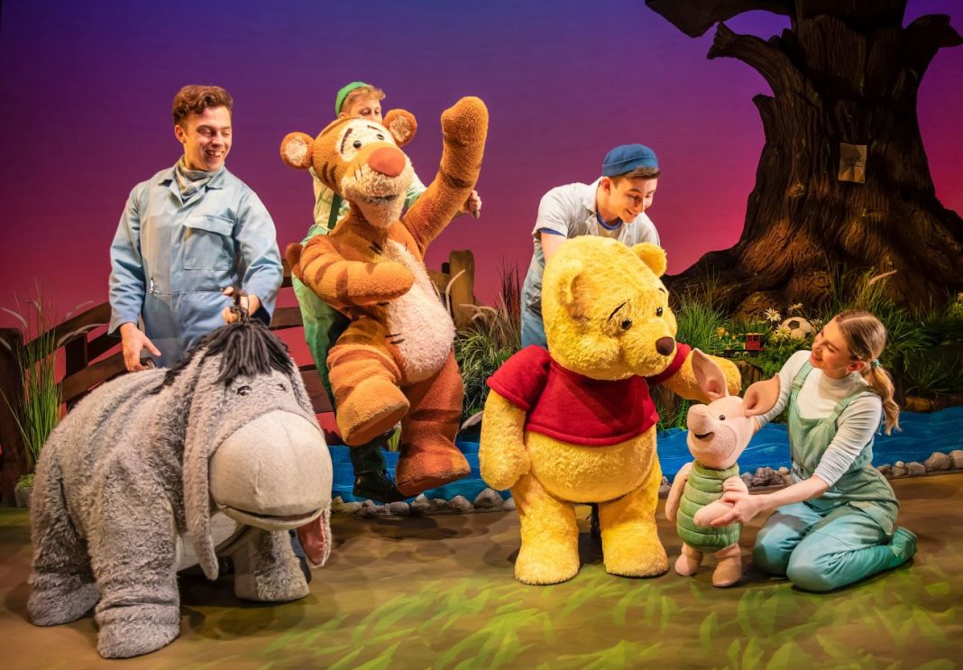 several puppeteers with Winnie the Pooh character puppets