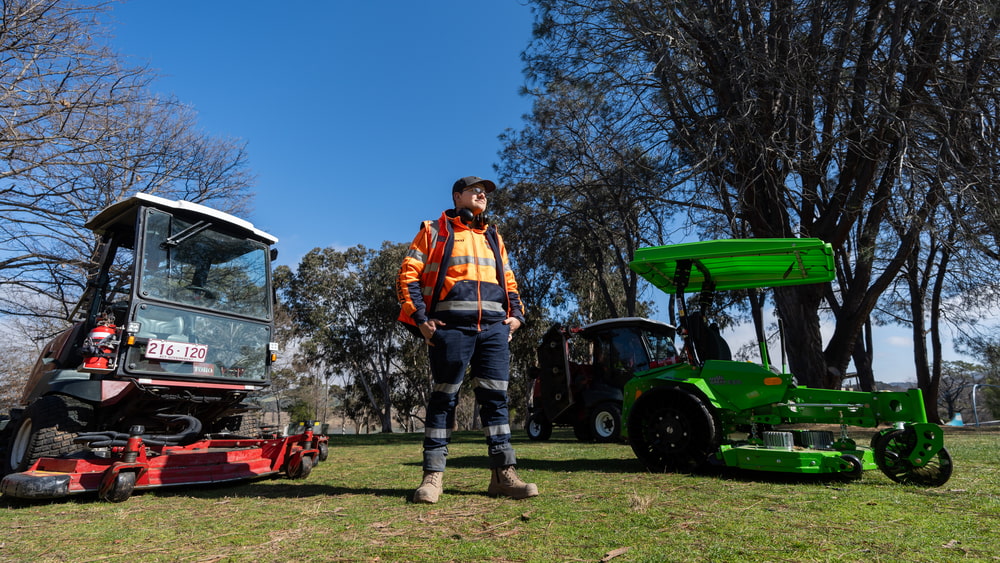 Angus Greene with the new electric mowers. Photo: ACT Government