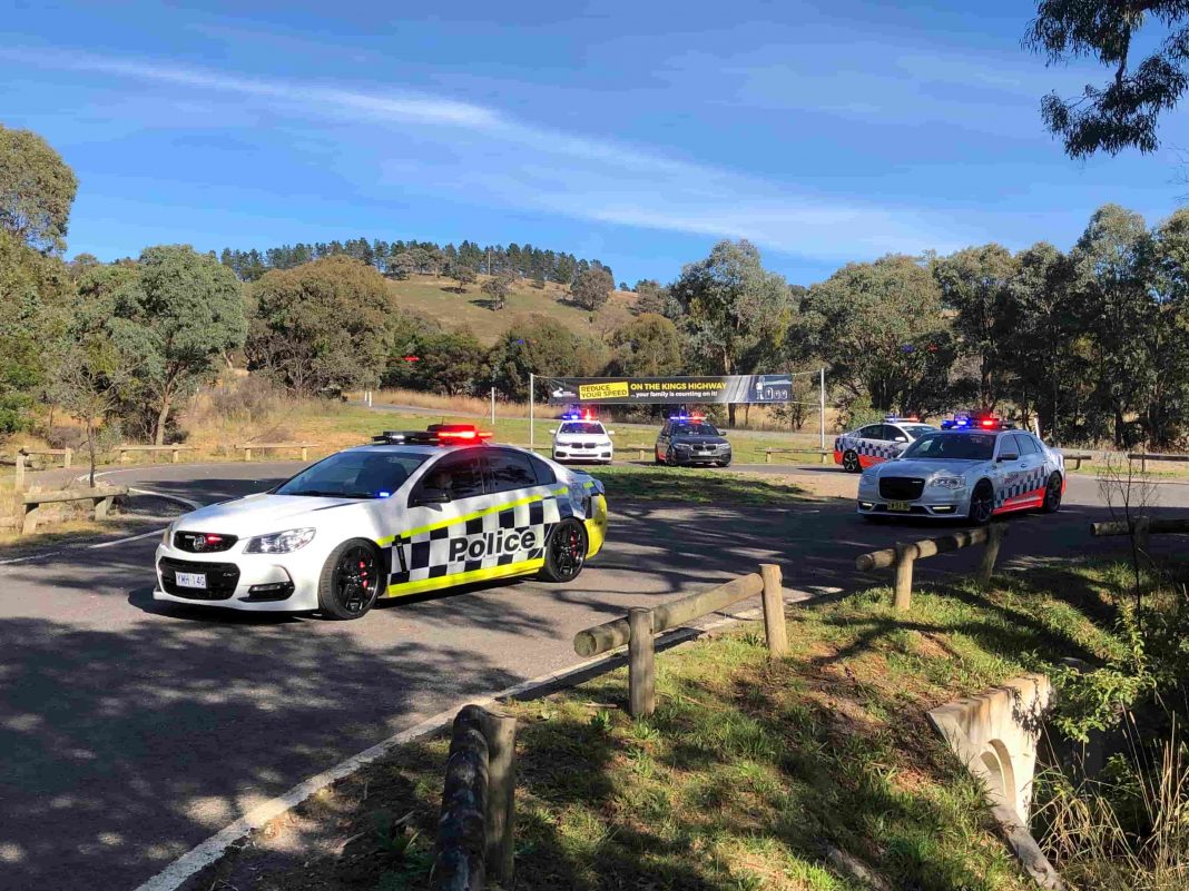 several ACT and NSW police cars parked at a rest stop near the border on the Kings Highway