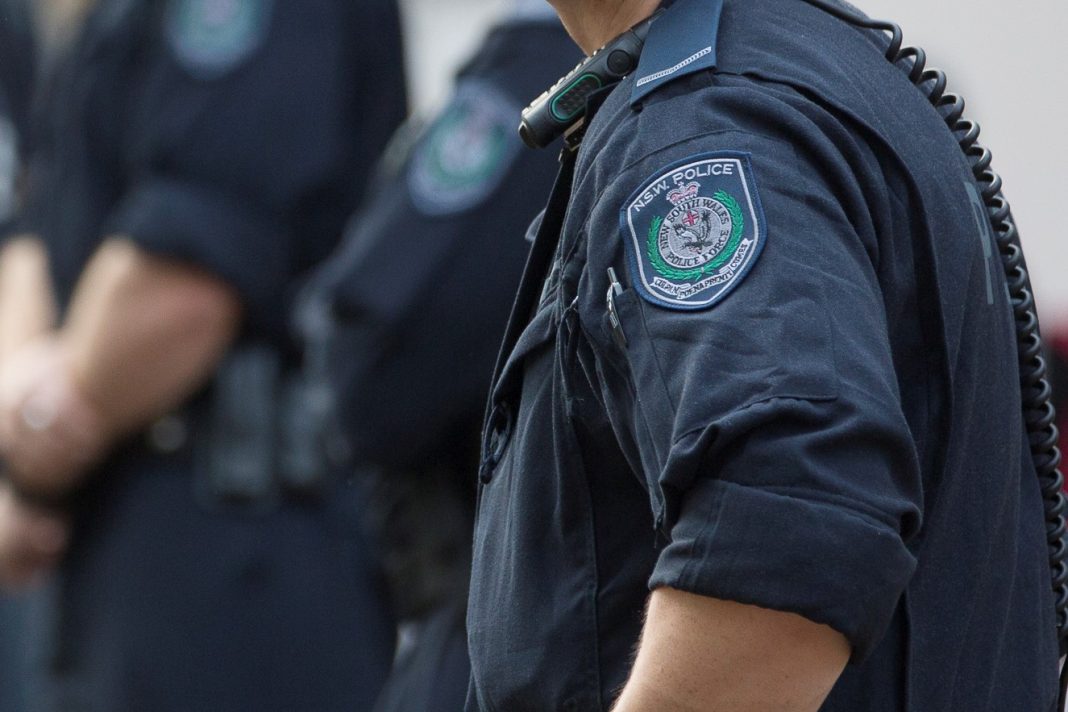 close up of NSW police badges on three officers in uniform