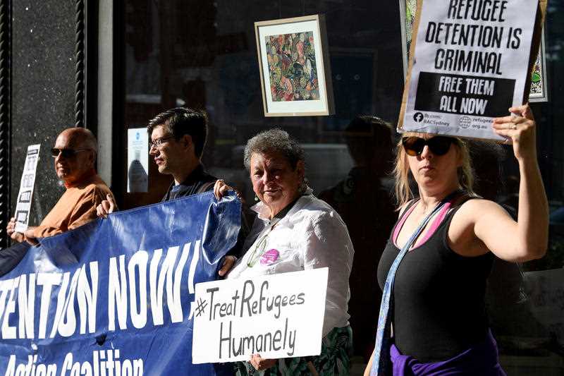 A small group of refugee supporters rally outside the Downing Centre Court, in Sydney, Tuesday, April 27, 2021