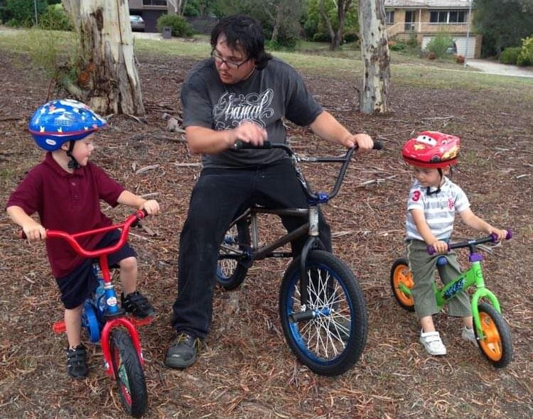 dad with 2 little boys on BMX bikes