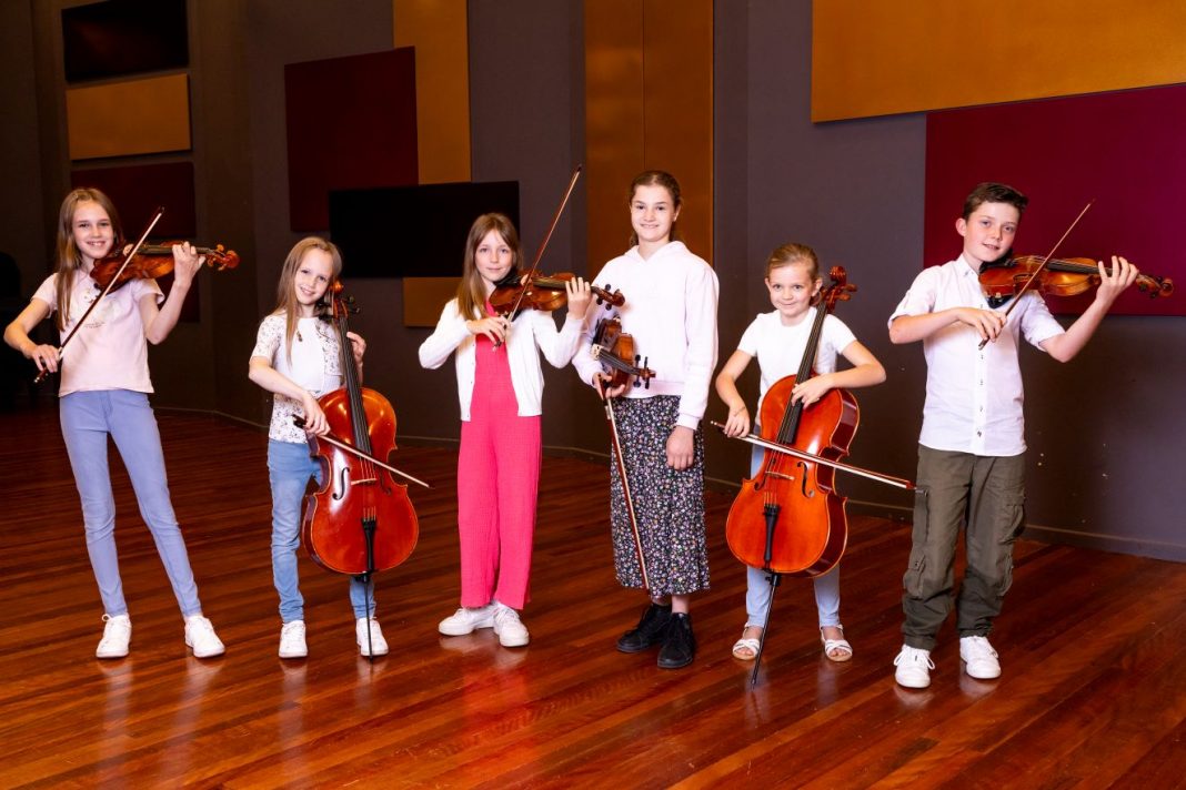 6 children playing string instruments