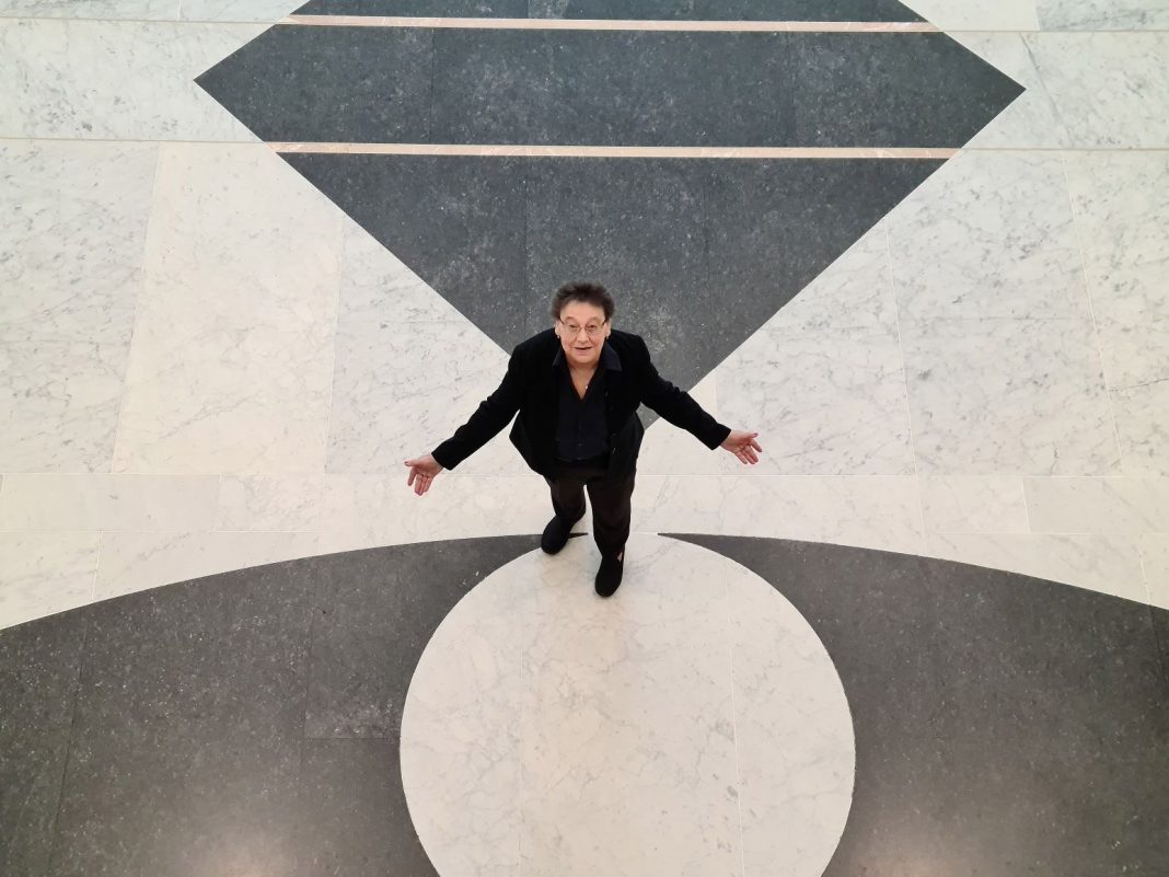 overhead view of 71 year old woman Maria Lubjic standing in the marble foyer of Australian Parliament House