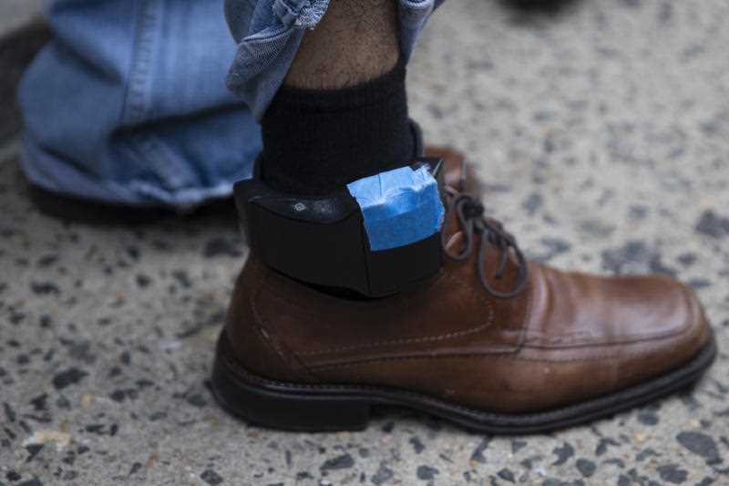 a man's leg is seen wearing an ankle monitor