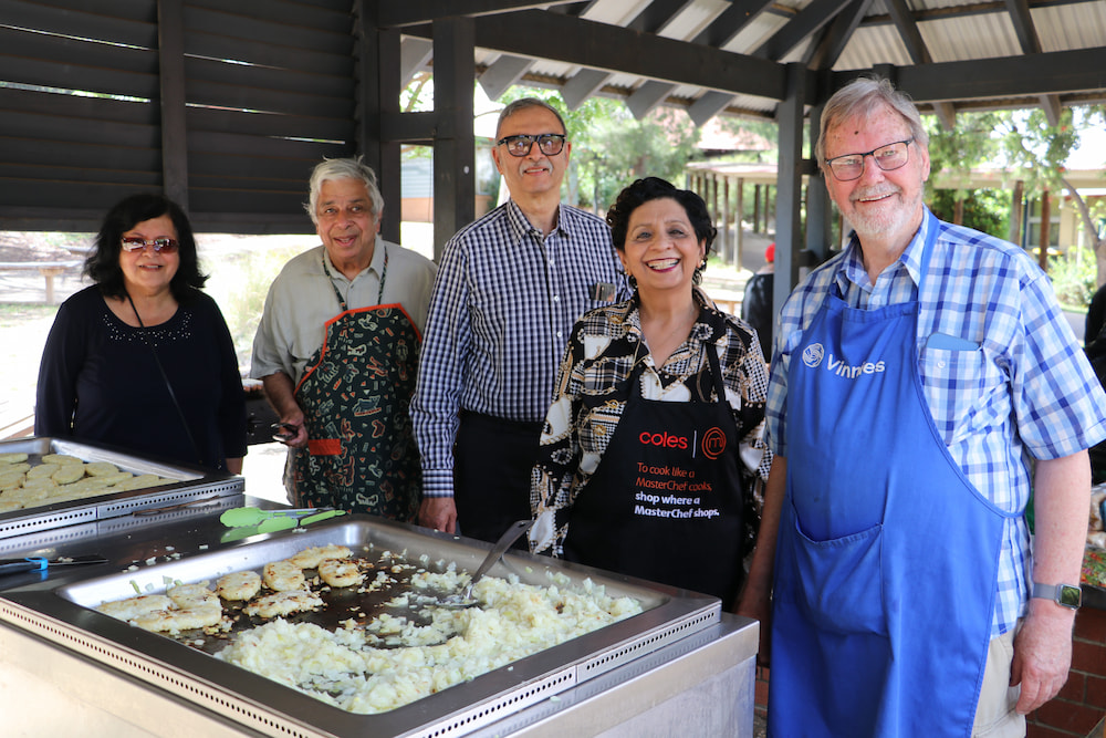 Nishi Puri and Paul Potter (at end), and friends cook a barbecue for homeless men at the Blue Door. Photo: Nicholas Fuller