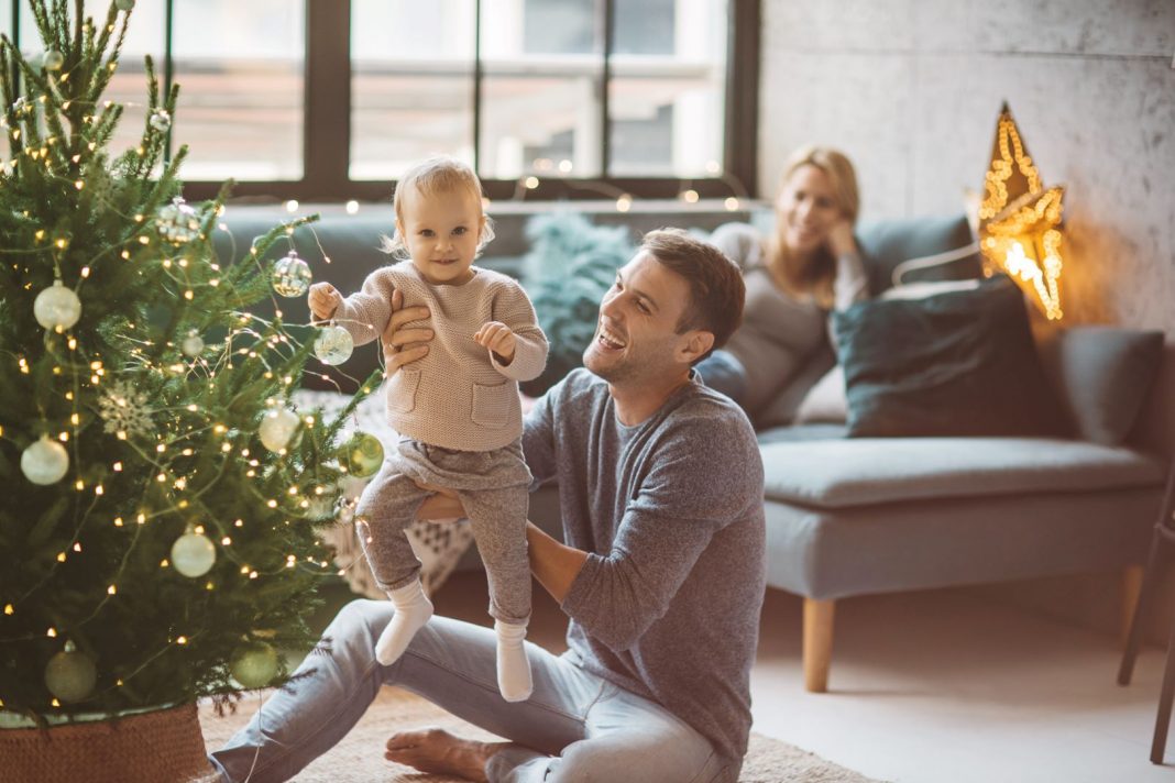 Young family gathered around a Xmas tree