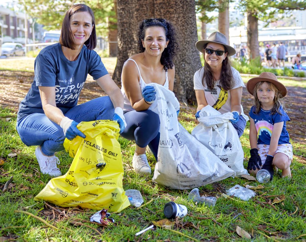 3 women and a girl picking up litter in a park on Clean Up Australia Day