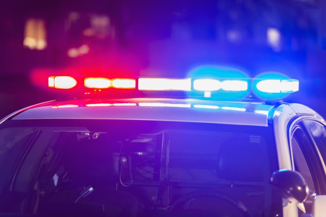 The roof of a police patrol car at night, with the blue and red lights flashing.