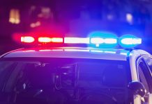 The roof of a police patrol car at night, with the blue and red lights flashing.