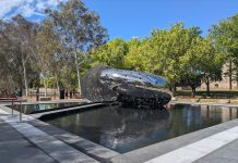 Lindy Lee’s Ouroboros sculpture levitates in a 240-square metre pond with a walkway guiding people into the “mouth” of the sculpture at the National Gallery of Australia. Picture: Lillian Altman