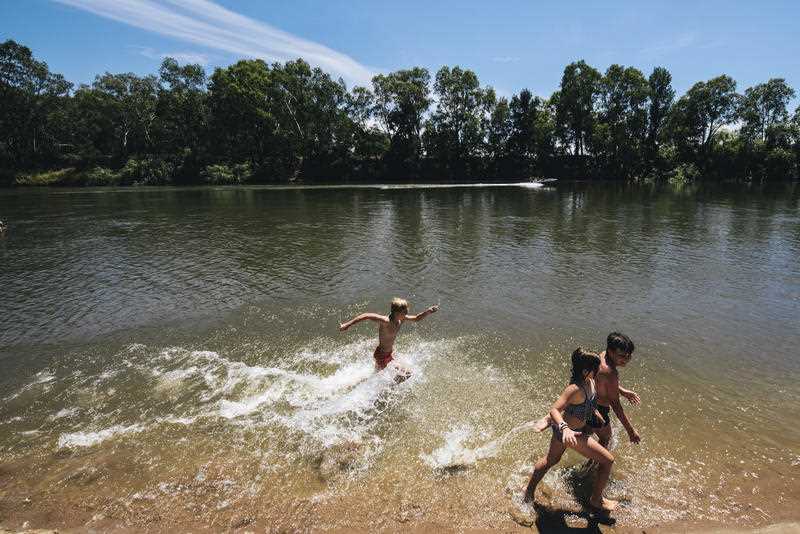 3 Children splash in the river at Wagga Wagga on a hot summer's day